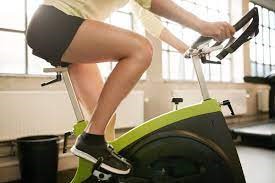 the leg and knee of a person on a stationary exercise bike