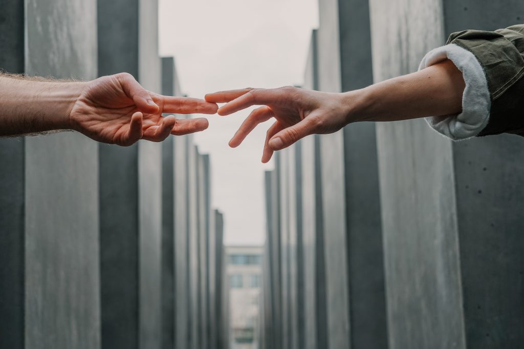 two peoples hands reaching out to each other for support and comfort